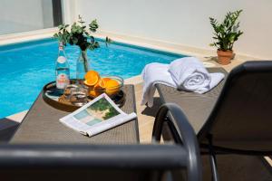 uma mesa com um tablet ao lado de uma piscina em Casa Triana 1888 Suites by Época em Sevilha