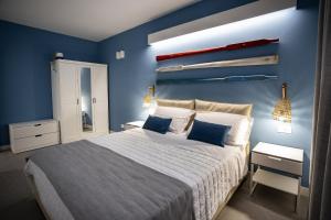 una camera da letto con un grande letto con pareti blu di Acquarò Suite Apartments a San Vito lo Capo