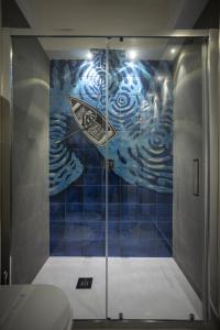 een badkamer met een douche en een schilderij aan de muur bij Acquarò Suite Apartments in San Vito lo Capo +44 foto's