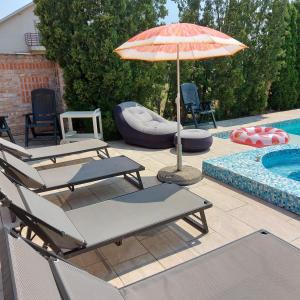a group of chairs and an umbrella next to a pool at Kuća na dan Villa Holiday in Sakule +38 photos