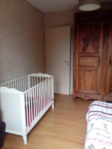 a room with a crib and a door and a bedroom at Chambre chez l'habitant in Valence