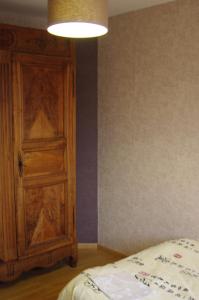 1 dormitorio con puerta de madera junto a la cama en Chambre chez l'habitant en Valence