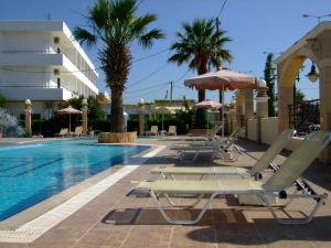 a group of lounge chairs and umbrellas next to a swimming pool at Antonios Hotel in Faliraki