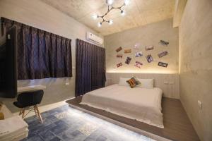 a bedroom with a white bed and a chair at 澎湖海景民宿 島嶼時光 Island Time Homestay in Magong