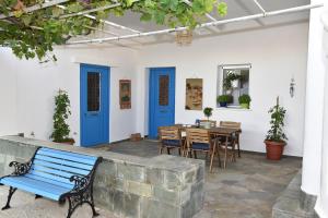 a patio with a blue bench and a table at Kampos Family Garden in Batsi