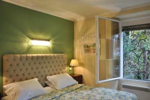 a bedroom with a bed and a window at Villa Sassalto in Lugano +2 photos