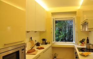 kuchnia z żółtymi ścianami i oknem w obiekcie Villa Sassalto w mieście Lugano