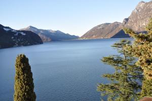 einen Blick auf einen See mit Bergen im Hintergrund in der Unterkunft Villa Sassalto in Lugano