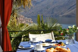 einen Tisch mit Essen drauf mit Blick auf den See in der Unterkunft Villa Sassalto in Lugano