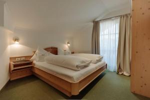 una camera da letto con un letto grande e una finestra di Ferienwohnungen Johanneshof a Maria Alm am Steinernen Meer