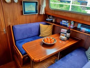 een tafel met een kom sinaasappels en een fles wijn bij Motor Yacht Amstelle in Amsterdam