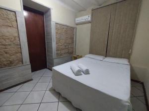 a bedroom with a white bed with towels on it at Hotel Castelo in Santana do Livramento