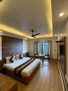 a bedroom with a large bed with a ceiling fan at Hotel Silverine in Shimla