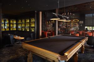 a pool table in a bar with alcohol bottles at Le Grand Hôtel Le Touquet-Paris-Plage in Le Touquet-Paris-Plage