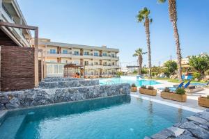 a resort with a swimming pool and palm trees at Dias Studios & Suites in Faliraki