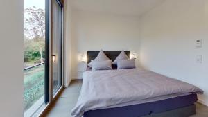 a bedroom with a bed and a large window at Haus Kleemann K4 in Norderney