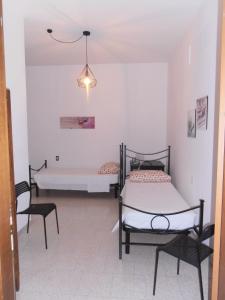 a room with two beds and two chairs at B&B Timo e Rosmarino in Sermide