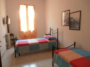 a bedroom with two beds and a window at B&B Timo e Rosmarino in Sermide