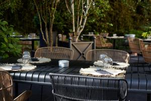 a black table with chairs and wine glasses on it at Le Grand Hôtel Le Touquet-Paris-Plage in Le Touquet-Paris-Plage