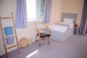 1 dormitorio con cama, escalera y silla en Heart of Zanzibar Bungalows, en Paje