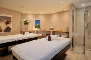 a hospital room with two beds and a shower at Le Grand Hôtel Le Touquet-Paris-Plage in Le Touquet-Paris-Plage