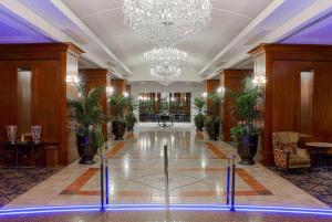 a lobby with chandeliers and plants in a building at The Antlers, A Wyndham Hotel in Colorado Springs