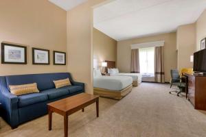 a living room filled with furniture and a tv at Comfort Suites Near Universal Orlando Resort in Orlando