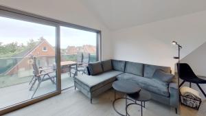 a living room with a couch and a large window at Haus Kleemann K4 in Norderney