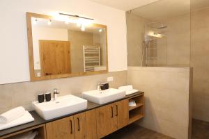 a bathroom with two sinks and a mirror at Lindbichlhof Urlaub am Bio Bauernhof in Sankt Johann im Pongau +66 photos