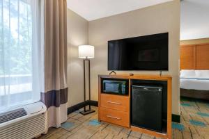 a hotel room with a flat screen tv and a bed at Comfort Suites near MCAS Beaufort in Beaufort