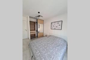 a bedroom with a bed in a white room at Saint Raphaël, bel appartement en centre ville ! in Saint-Raphaël