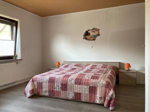 una camera con un letto con una coperta rossa e bianca di Ferienhaus Kuddel a Zempin