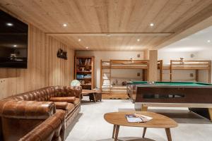 a living room with a couch and a pool table at Chalet familial Fleurs des Bois - Rochebrune in Megève