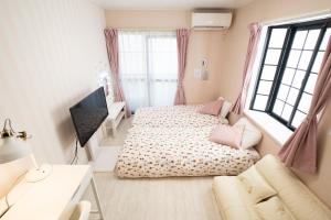 Postel nebo postele na pokoji v ubytování ローズパーク弐番館