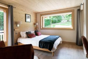 a bedroom with a bed and a window in a room at Chalet familial Fleurs des Bois - Rochebrune in Megève