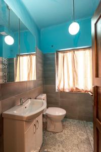 a bathroom with a sink and a toilet and a mirror at Theatre Old Town House in Bitola