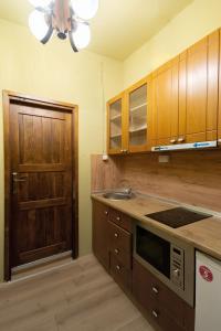 a kitchen with wooden cabinets and a sink and a door at Theatre Old Town House in Bitola
