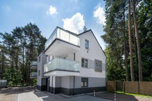 a white house with glass windows at Apartamenty 7 Fal in Pobierowo