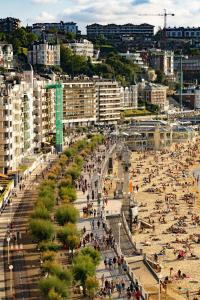 una playa con mucha gente y edificios en La Ostra de Mirakontxa en San Sebastián