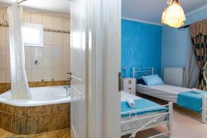 een badkamer met een bad en een slaapkamer met een bed bij Villa Angelina in Alykes