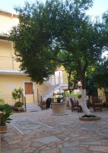 a tree in front of a building with a staircase at Villa Avli in Parga