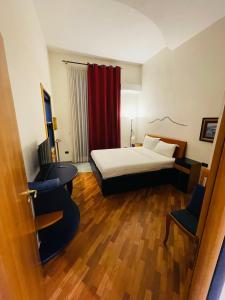 ナポリにあるSanta Maria La Nova 21 Rooms & Suitesのベッドと椅子付きのホテルルーム