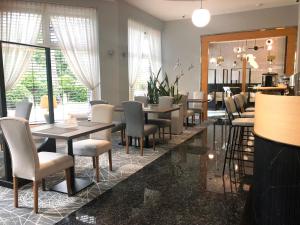 a dining room with tables and chairs and windows at Hotel Morskie Oko in Jurata