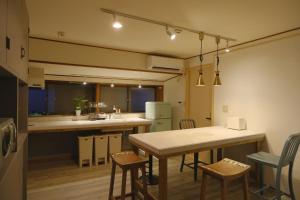 cocina con mesa y sillas en una habitación en 1日1組限定 プライベート空間 古民家貸切コテージとけい en Kurita