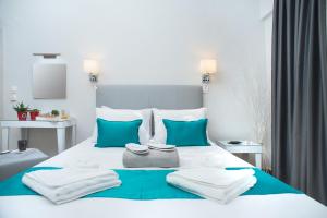 Una cama blanca con almohadas azules y toallas. en Lux VIP Apartments en Perea