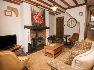 a living room with a couch and a fireplace at Ascot Cottage in York