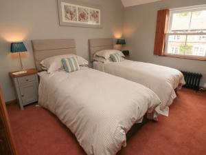 a bedroom with two beds and a window at Ascot Cottage in York