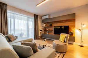 uma sala de estar com um sofá e uma televisão em North Twin3 em Bucareste