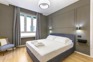 ein Schlafzimmer mit einem großen Bett und einem Stuhl in der Unterkunft ALMi in Cagliari