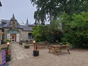 un patio con mesas de picnic y un edificio en Fieldways en Trowbridge